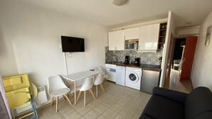 A compact living space with a kitchenette, a dining area, and a sofa. - Sol-y-Days le Goéland, Seafront apartment with parking (Le Grau-du-Roi)