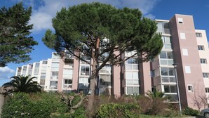 Um edifício de apartamentos com várias andares, varandas e janelas amplas.
