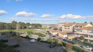 Área residencial com edifícios de apartamentos, um estacionamento e céu aberto.