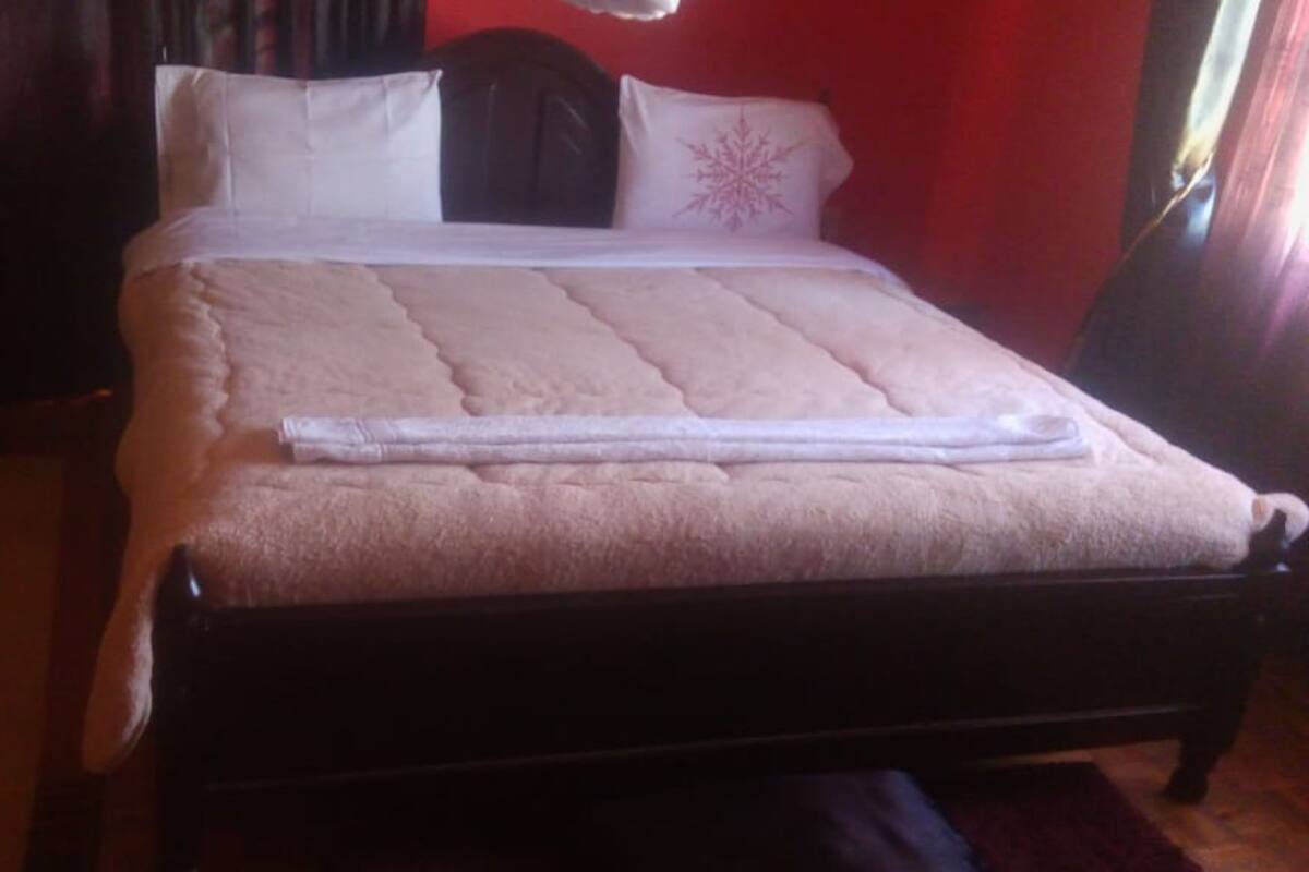 A bed with a white bedspread and a folded towel.