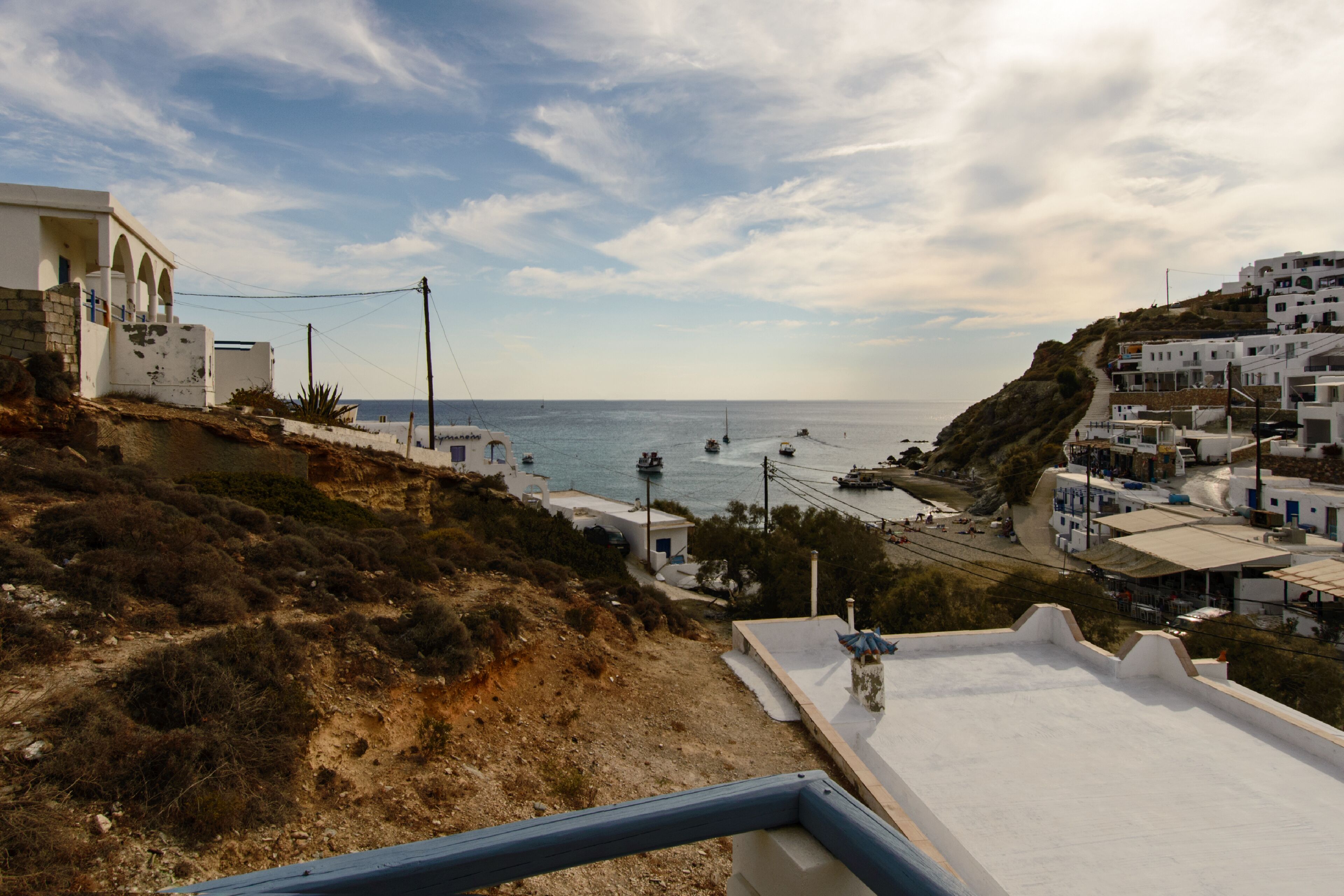 A coastal town with white buildings, a clear sky, and boats on the sea.