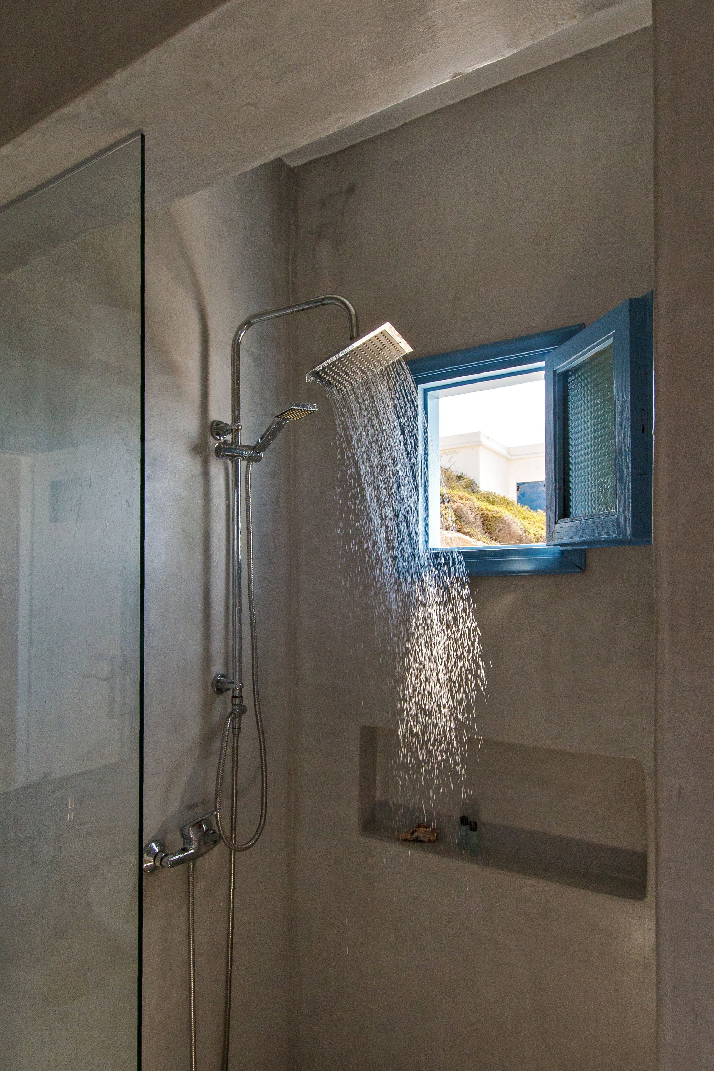 Ducha con ventana, cabezal de ducha de mano y grifo empotrado.