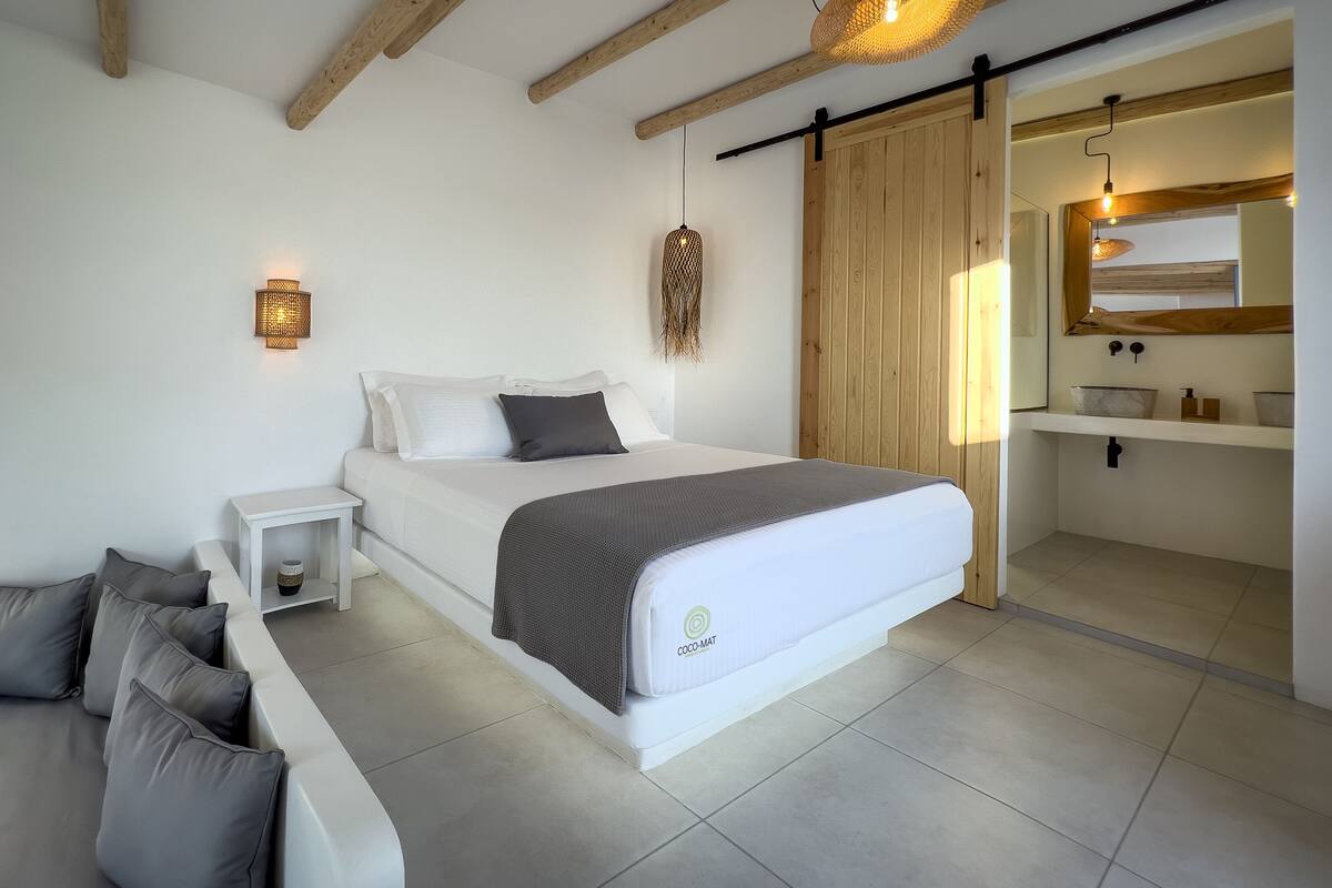 A modern bedroom with a bed, bedside table, and a built-in bench.