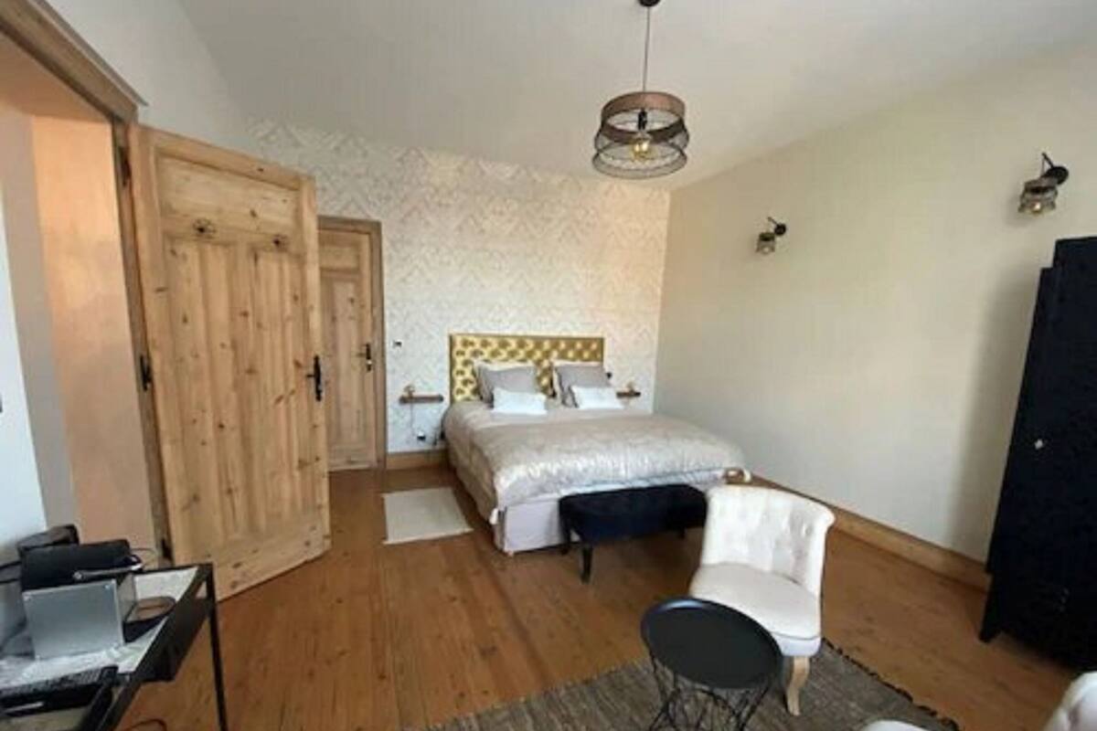 A bedroom with a bed, a desk, a chair, and a wardrobe.