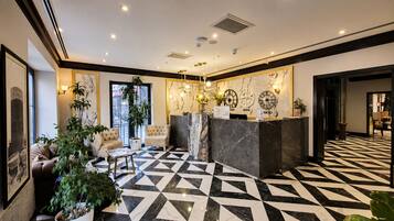Un hall d’hôtel comprenant un comptoir d’enregistrement, un espace salon et un sol décoré de motifs.