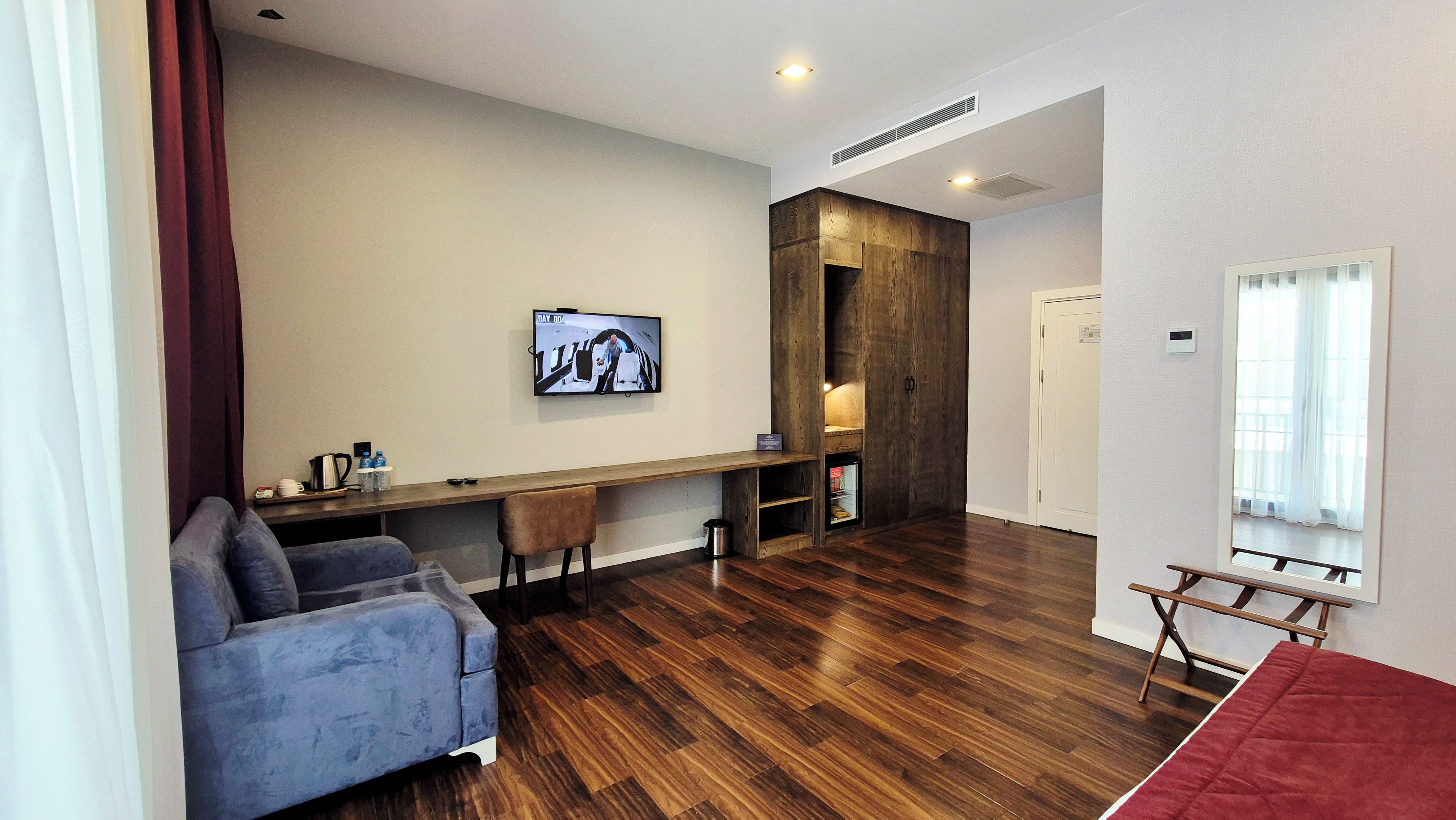 Un salon moderne avec un canapé, une table à manger en bois et un téléviseur fixé au mur.