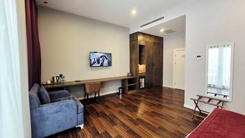 Un salon moderne avec un canapé, une table à manger en bois et un téléviseur fixé au mur.