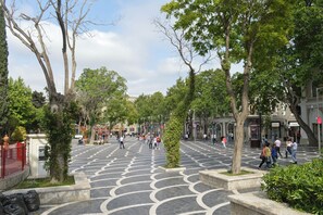A spacious public square with a patterned pavement, surrounded by trees and buildings. - Port Rivoli Baku Hotel (Baku)