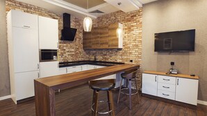A modern kitchen with a wooden island, bar stools, and a built-in oven.