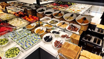 Buffet com diversos pratos e acompanhamentos.