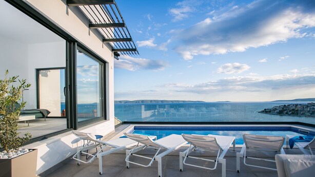 A rooftop pool area with lounge chairs and a view of the sea. - The Olive Exclusive holiday home (Okrug)