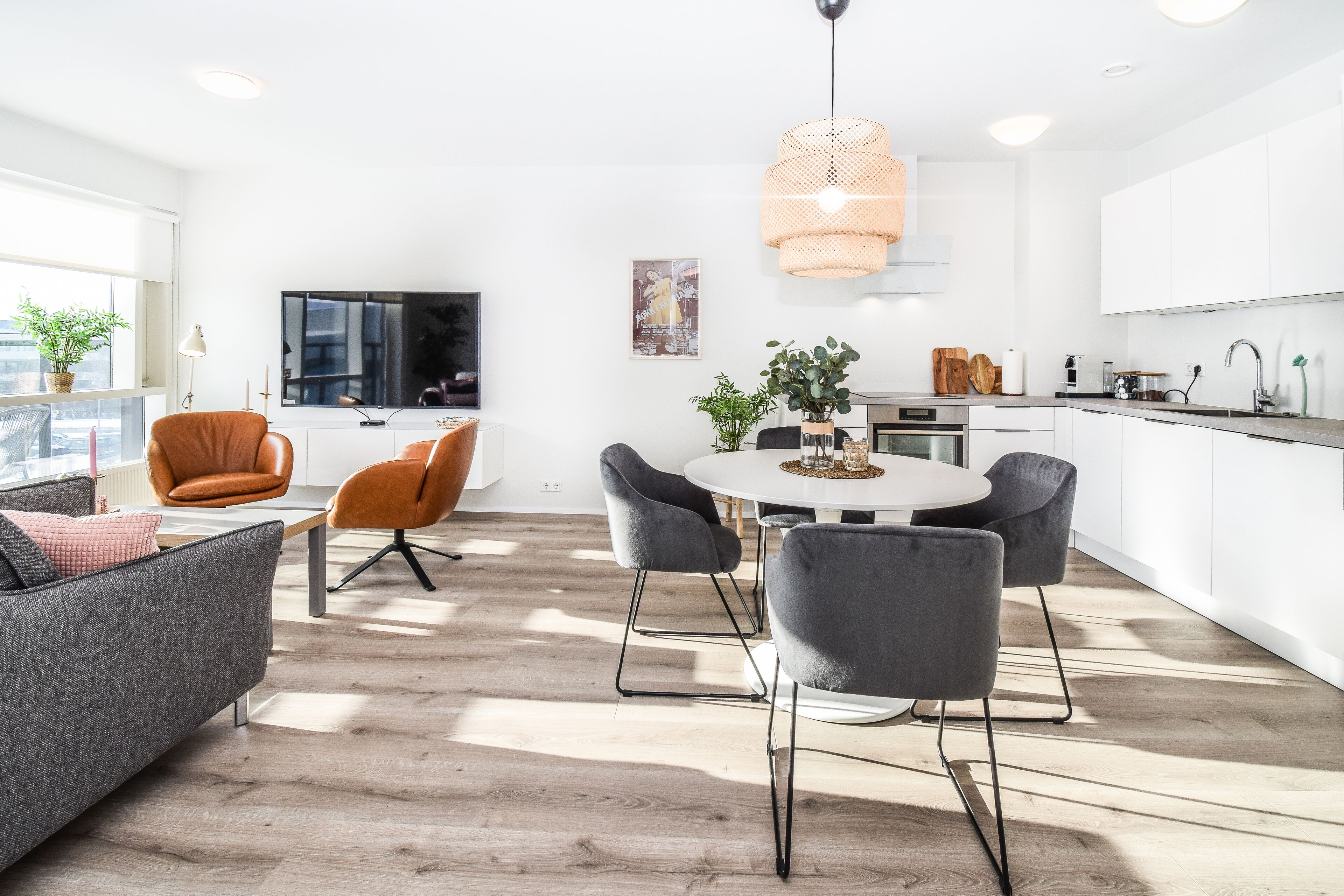 Un espace de vie moderne comprenant un coin repas, une cuisine et un espace détente.