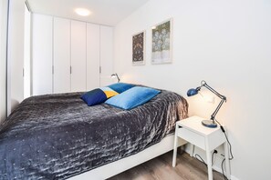 Ein Schlafzimmer mit Bett, Schreibtisch und Kleiderschrank.
