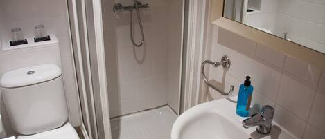A bathroom with a shower, toilet, and sink.