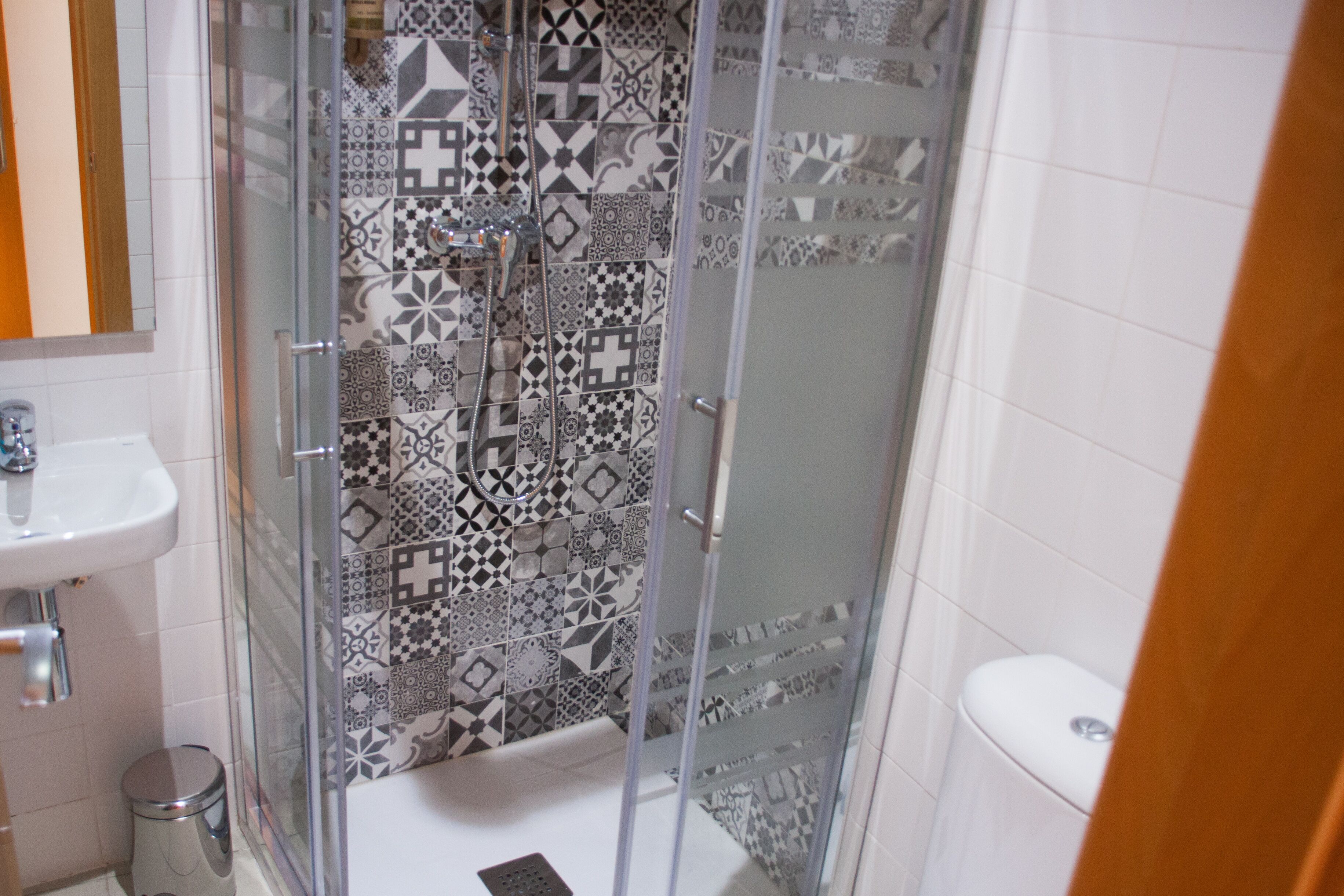Une salle de bain avec une douche à parois de verre, un lavabo et des toilettes.