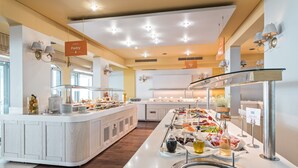 A buffet area with a variety of food options, including a section labeled "Pastry" and another labeled "Bacon."