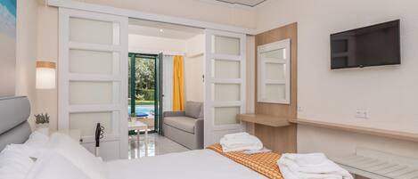Una habitación de hotel moderna con cama, televisor, escritorio y vistas al exterior.