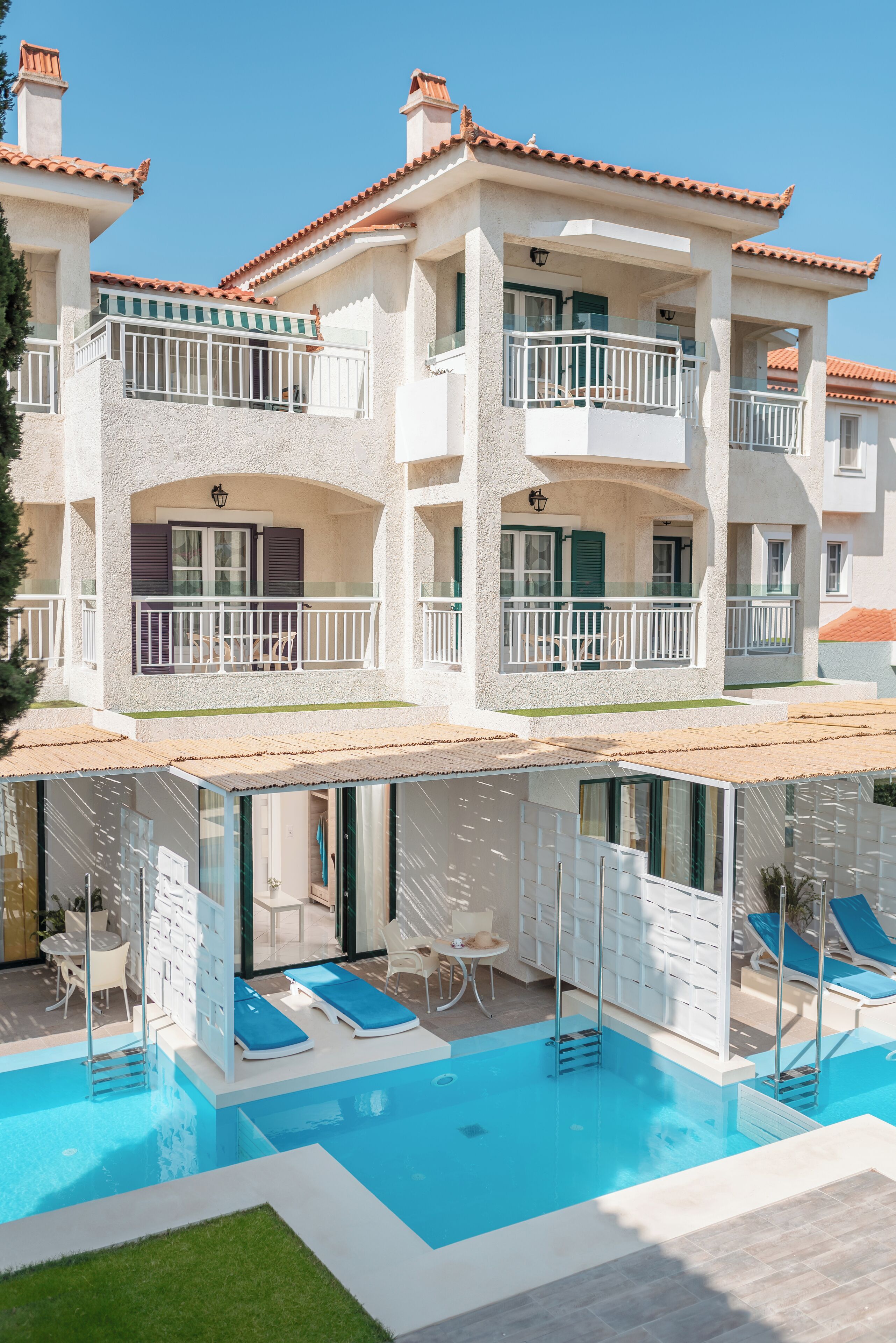 Ein Hotel mit Schwimmbad, Balkonen und einer Terrassenanlage.
