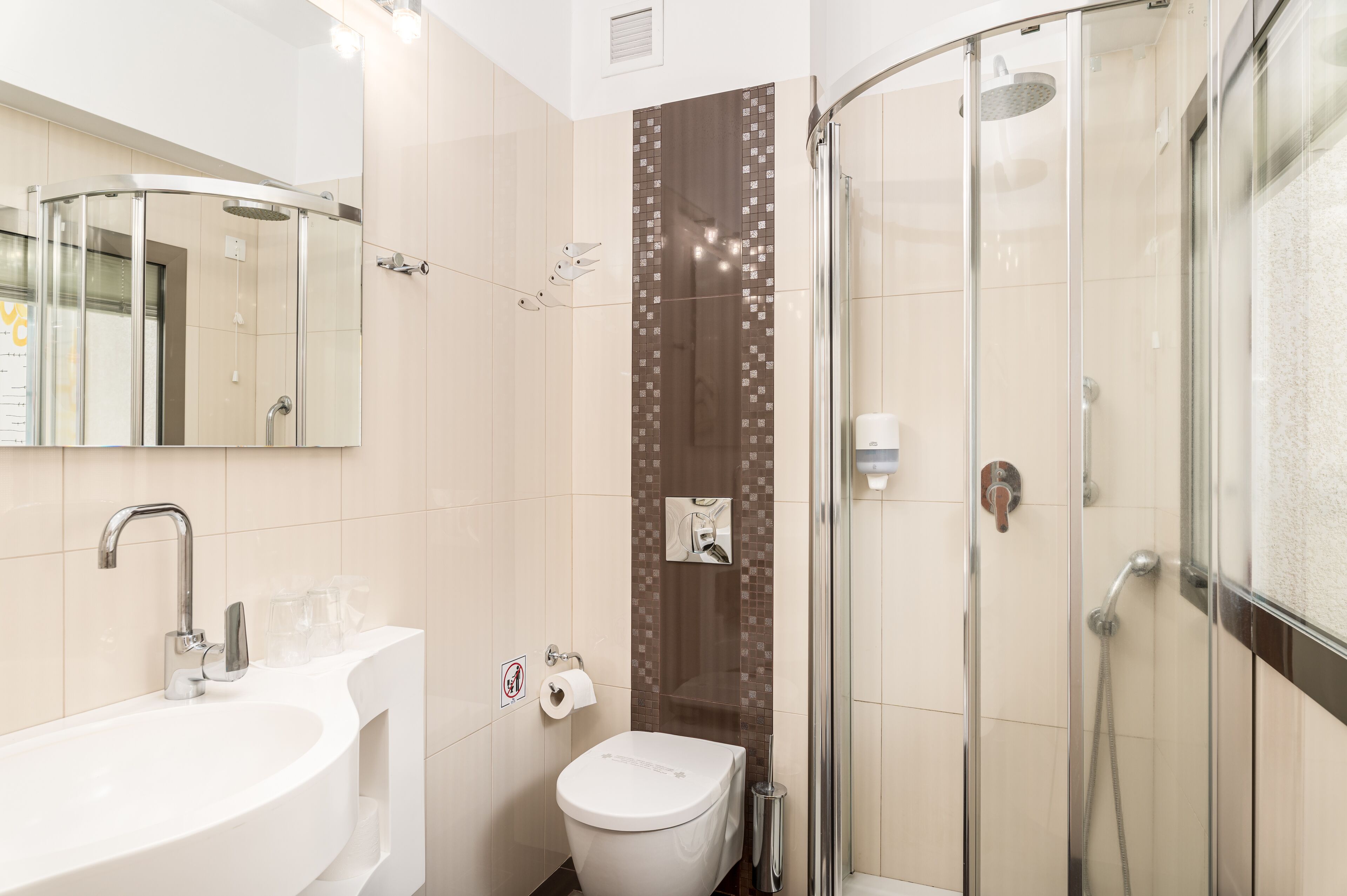 A modern bathroom with a sink, toilet, and shower.