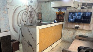 A reception area with a marble counter, a television mounted on the wall, and a sign indicating outside food is allowed.