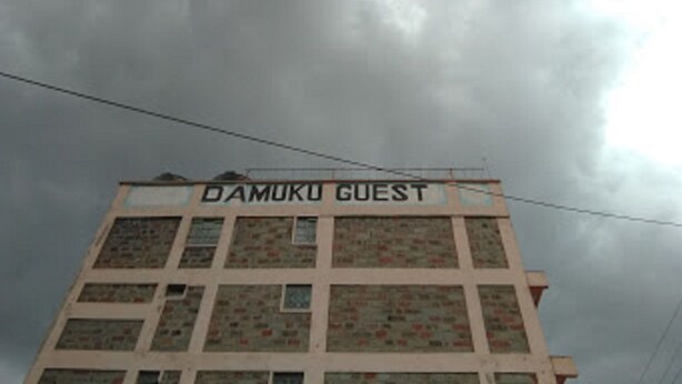 Un edifici amb el rètol "DAMUKU GUEST" a la part superior.
