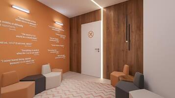 A modern waiting area with a wooden wall, a white door, and several seating options.