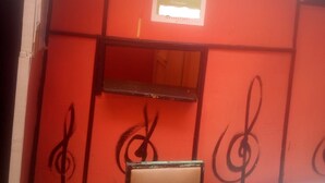 Una habitació amb una paret vermella, un sostre blanc i una cadira amb una taula.