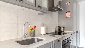 A modern kitchen with two sinks, stainless steel appliances, and a marble countertop. - The Best Apartment in Lisbon, Praça da Alegria (Lisboa)
