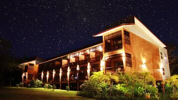 A two-story building with multiple balconies, under a starry night sky.