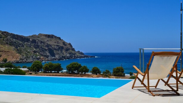 Una piscina con vista al mar y a las montañas.