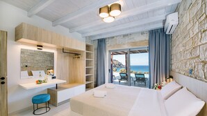Un dormitorio moderno con una cama grande, un escritorio integrado y vistas al mar.