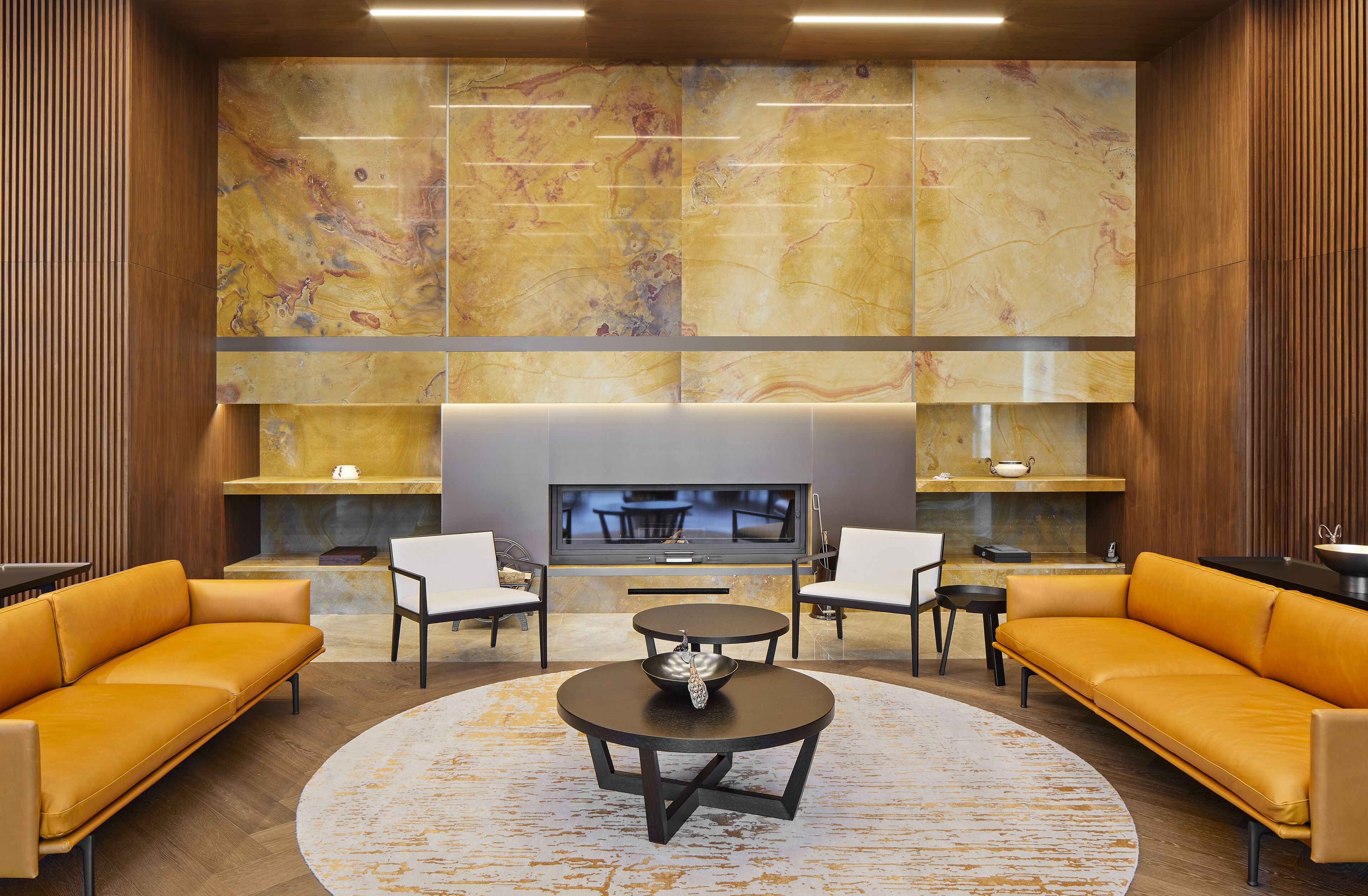 A modern living room with a large TV, two sofas, a coffee table, and a fireplace.