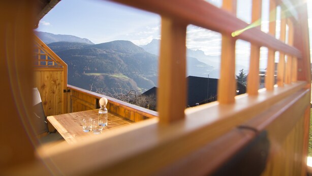 Een houten balkon met uitzicht op bergen.