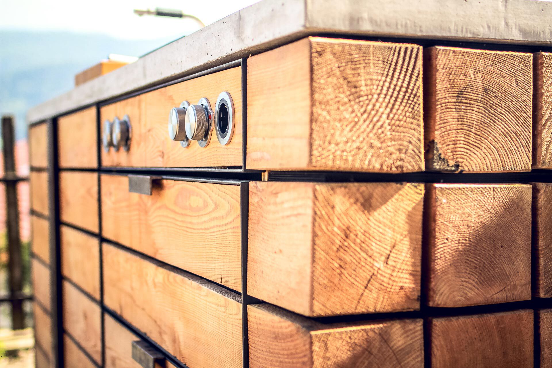 Een houten constructie met verschillende vakken, elk voorzien van een metalen hendel.