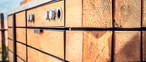 Een houten constructie met verschillende vakken, elk voorzien van een metalen hendel.