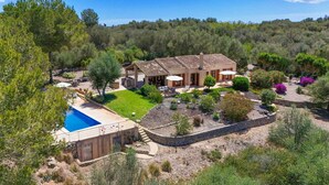 Une villa de style méditerranéen dotée d’une piscine, d’un espace salon extérieur et d’un jardin aménagé.