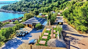 Un hotel costero con recepción, asientos al aire libre y vista al mar.