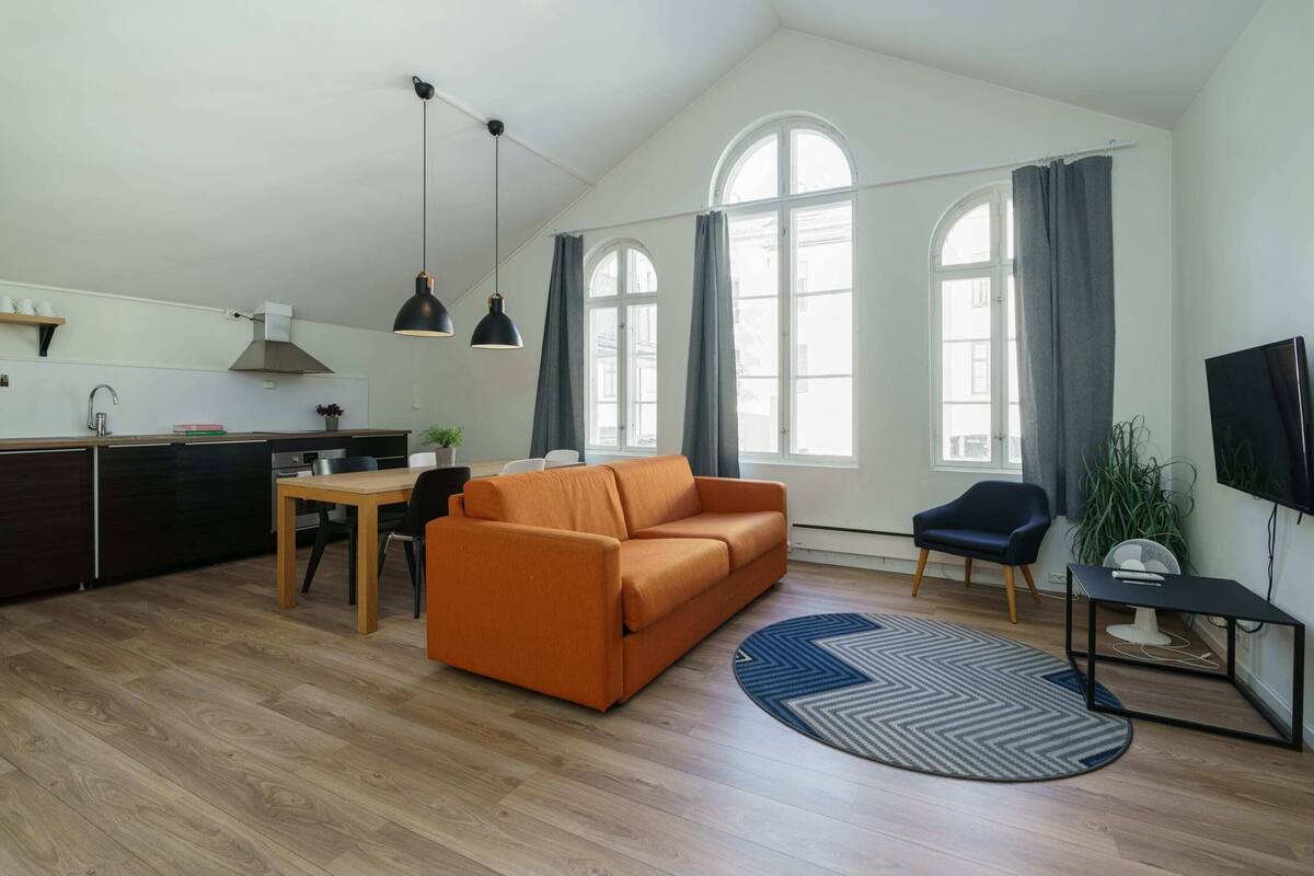 A modern living space with a kitchen, dining area, and seating area.