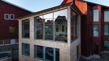 Un bâtiment moderne doté de grandes fenêtres et d’une façade en bois.
