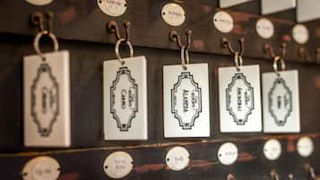 A wall with multiple tags hanging from hooks, each with a label and a name.