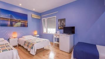 Habitación de hotel con dos camas, un escritorio, un televisor y un cuadro de un puente.