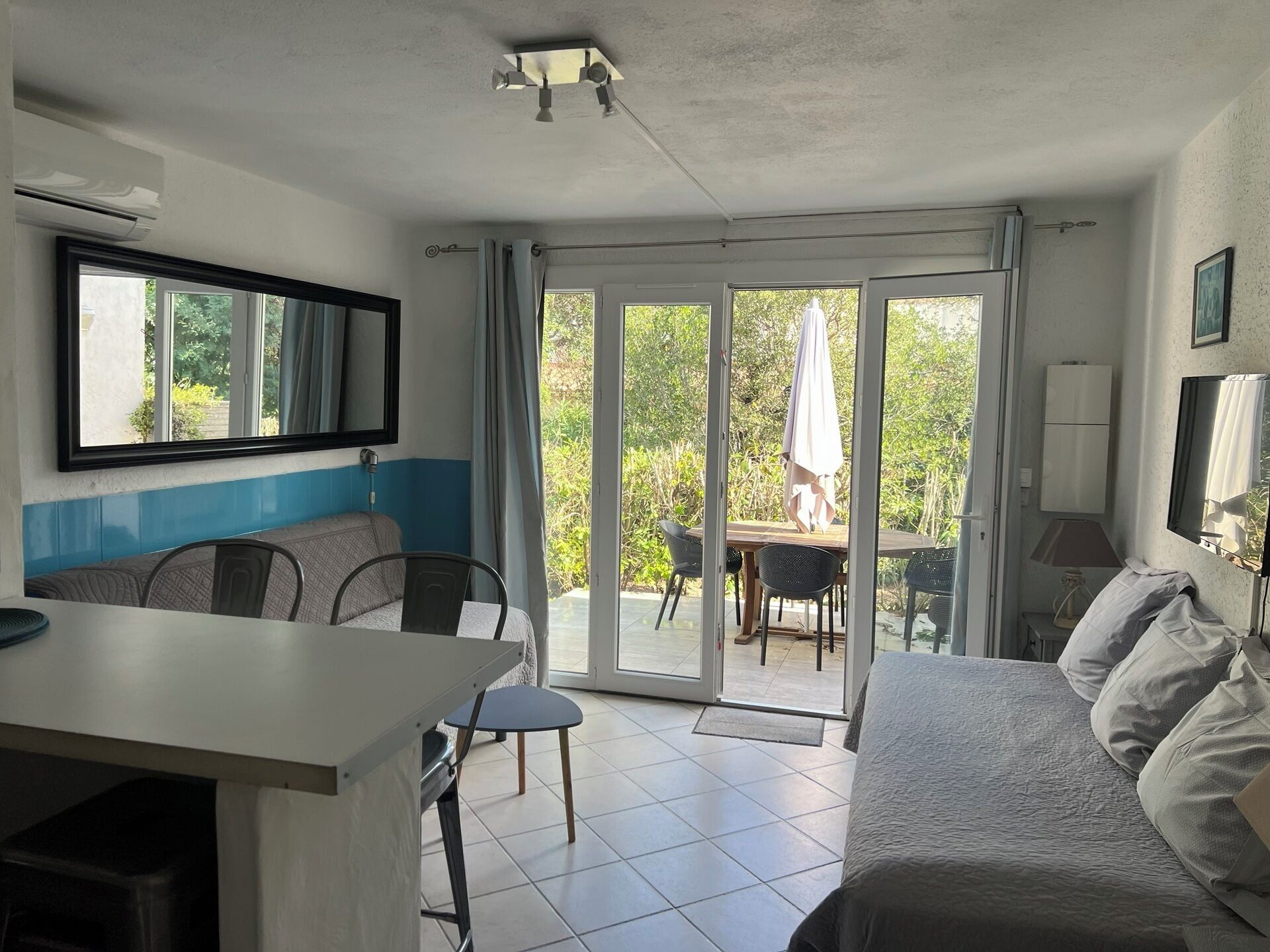 A room with a bed, a desk, and a dining area with chairs and a table.
