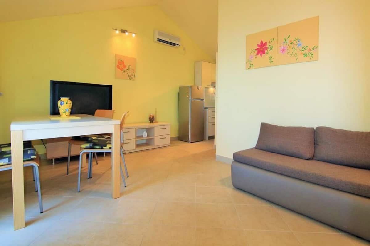 Un espace de vie compact comprenant un coin repas, une kitchenette et un canapé.