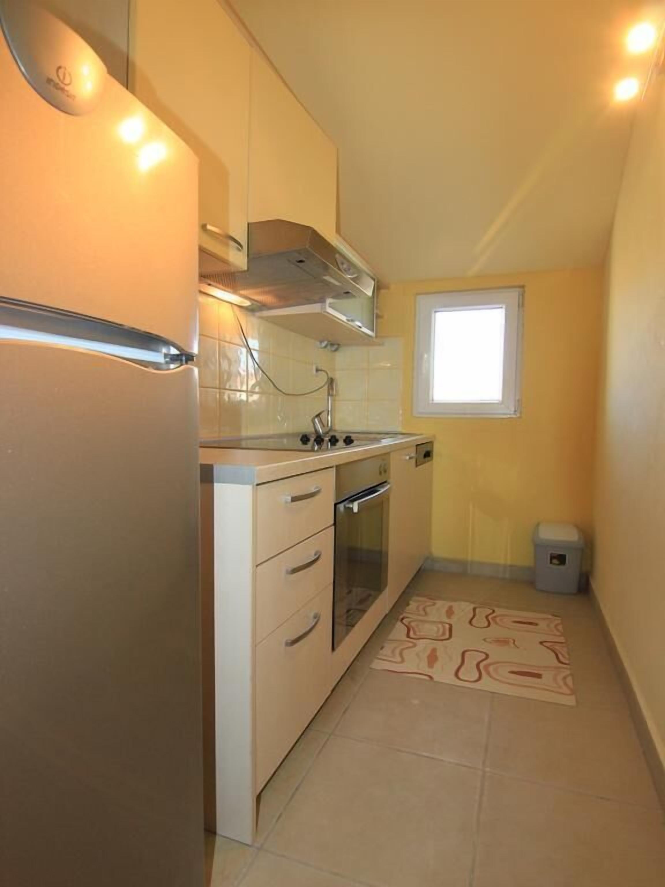 Una cocina compacta con horno integrado, microondas y estufa.