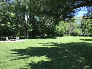 Un espace verdoyant bien entretenu, agrémenté d’arbres et d’une table de pique-nique.