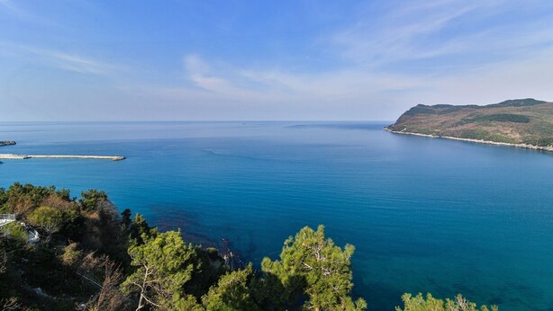 A coastal landscape with a clear view of the sea, a pier, and a hilly terrain. - Amasra Sunrise Otel (Amasra)