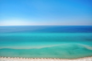 A beach with clear turquoise waters and a sandy shore.
