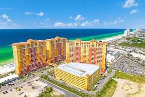 A multi-story hotel with a central courtyard, located near a beach with clear blue waters. - Calypso Resort by BBG (Panama City Beach)