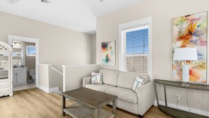 A living room with a sofa, coffee table, and artwork on the walls. - Amazing Place - 1232960 (Santa Rosa Beach)