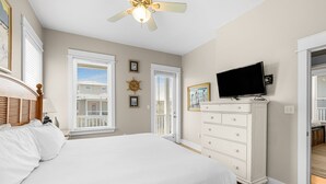 A bedroom with a large bed, a ceiling fan, a television on a dresser, and a view of the outside balcony. - Amazing Place - 1232960 (Santa Rosa Beach)